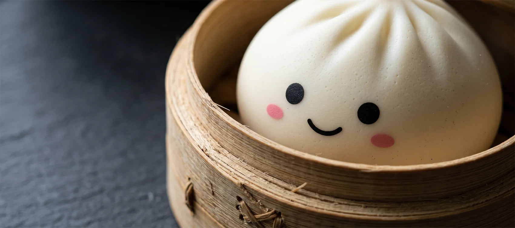 Macro shot of a cream-white kawaii dumpling squishy with pink cheeks in a bamboo steamer on dark slate