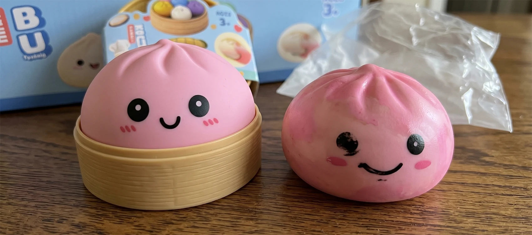 A matte pink dumpling squishy with a clean printed kawaii face next to a poorly painted counterfeit