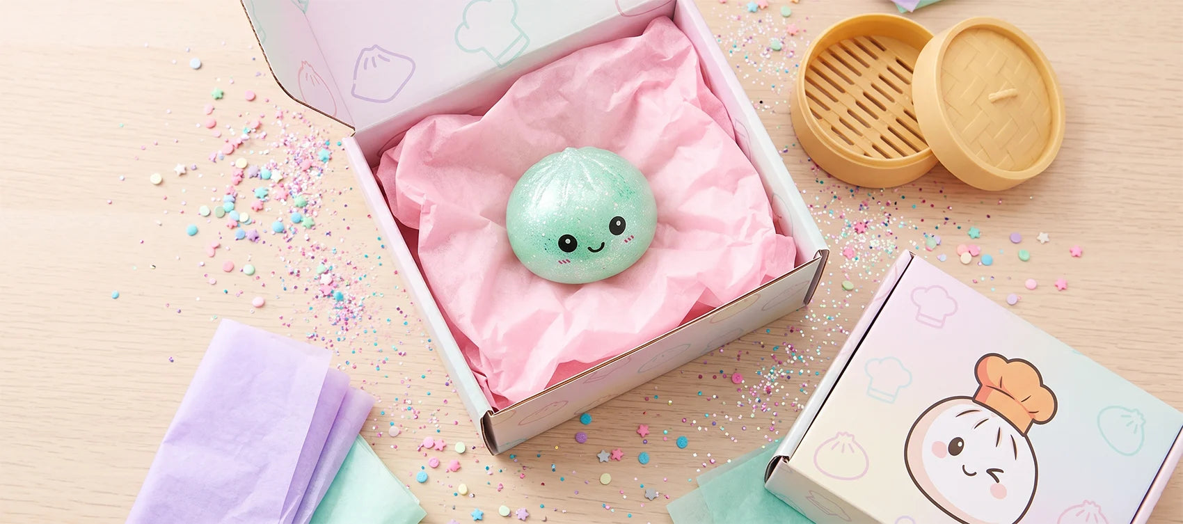 An open mystery blind box revealing a cute dumpling squishy surrounded by glitter and pastel tissue paper